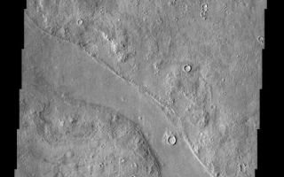 <h1>PIA04081:  Complex and Perplexing Mars</h1><div class="PIA04081" lang="en" style="width:471px;text-align:left;margin:auto;background-color:#000;padding:10px;max-height:150px;overflow:auto;"><p><a href="/figures/PIA04081_context.jpg"></a><br><p>A variegated mottled texture is readily apparent in this terrain located NW of the volcano, Elysium Mons. The Hrad Vallis (the Armenian word for Mars) channel system can be seen sauntering across the bumpy landscape of Utopia Planitia. The upper branch of Hrad Vallis has a large chunk of material on its floor; this chunk appears to have been rafted away from the material on the far left of the image (moved from left to right). This unusual because the channel flows toward the left. This material may be lava flows. Many craters in this region of the planet have their interiors filled with material. Pedestal craters (craters with ejecta blankets perched higher than the surrounding plains) are also found in these regions. These observations seem to imply that this region was once buried and has now been uncovered (exhumed). The exact causes and timing of these events are unknown.<p>Note: this THEMIS visual image has not been radiometrically nor geometrically calibrated for this preliminary release. An empirical correction has been performed to remove instrumental effects. A linear shift has been applied in the cross-track and down-track direction to approximate spacecraft and planetary motion. Fully calibrated and geometrically projected images will be released through the Planetary Data System in accordance with Project policies at a later time.<p>NASA's Jet Propulsion Laboratory manages the 2001 Mars Odyssey mission for NASA's Office of Space Science, Washington, D.C. The Thermal Emission Imaging System (THEMIS) was developed by Arizona State University, Tempe, in collaboration with Raytheon Santa Barbara Remote Sensing. The THEMIS investigation is led by Dr. Philip Christensen at Arizona State University. Lockheed Martin Astronautics, Denver, is the prime contractor for the Odyssey project, and developed and built the orbiter. Mission operations are conducted jointly from Lockheed Martin and from JPL, a division of the California Institute of Technology in Pasadena.<p>Image information: VIS instrument. Latitude 40.6, Longitude 134.2 East (225.8 West). 19 meter/pixel resolution.<p><br /><br /><a href="http://photojournal.jpl.nasa.gov/catalog/PIA04081" onclick="window.open(this.href); return false;" title="Voir l'image 	 PIA04081:  Complex and Perplexing Mars	  sur le site de la NASA">Voir l'image 	 PIA04081:  Complex and Perplexing Mars	  sur le site de la NASA.</a></div>